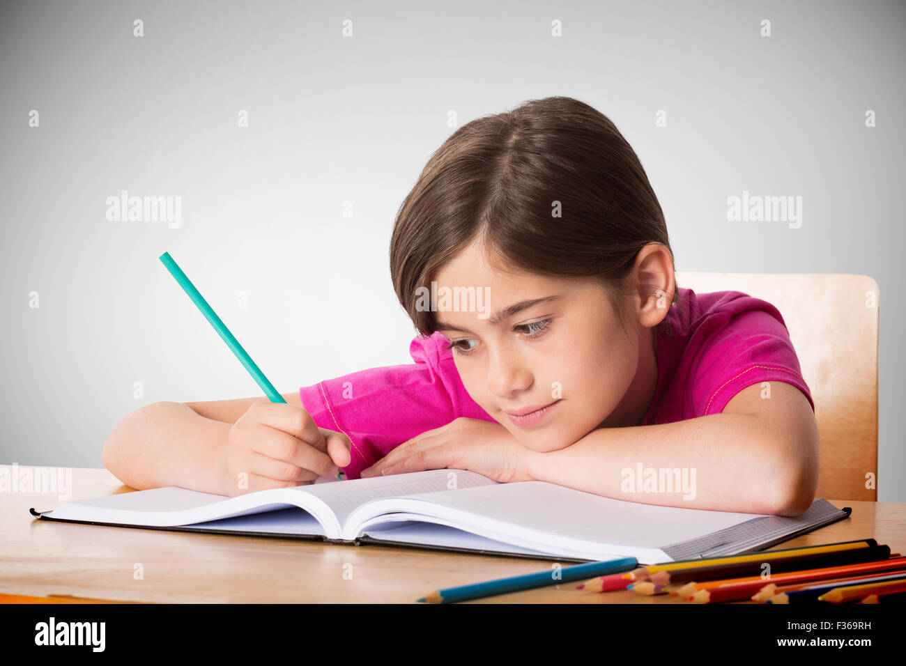 Composite image of cute pupil working at her desk Stock Photo - Alamy