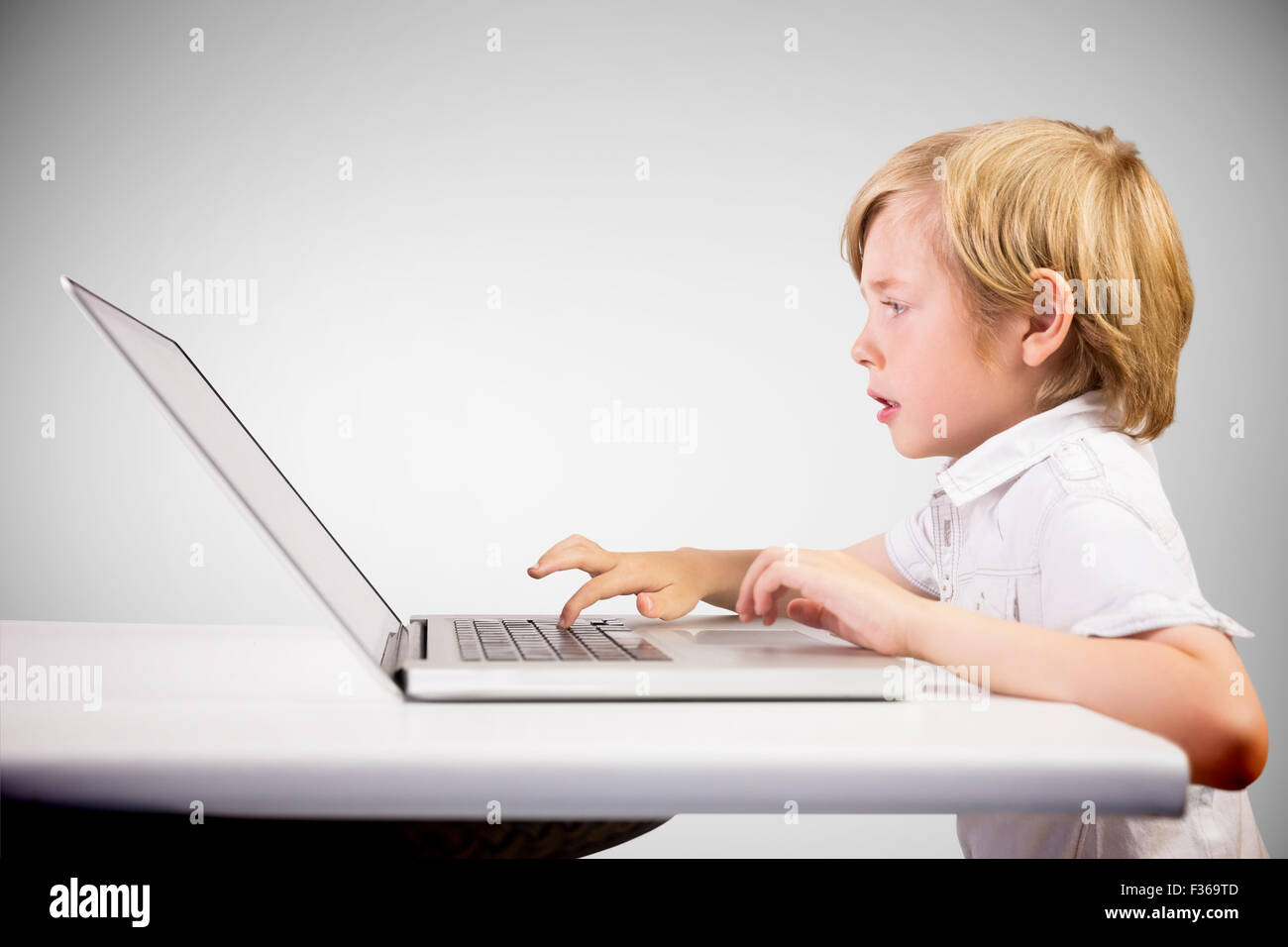 Composite image of cute boy using laptop Stock Photo - Alamy