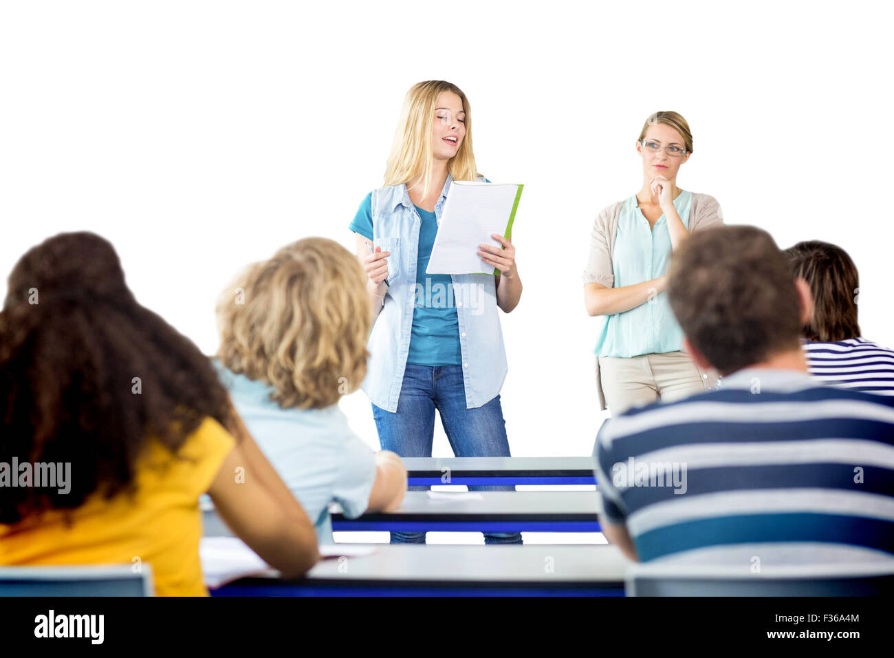 Student explaining notes besides teacher in class Stock Photo