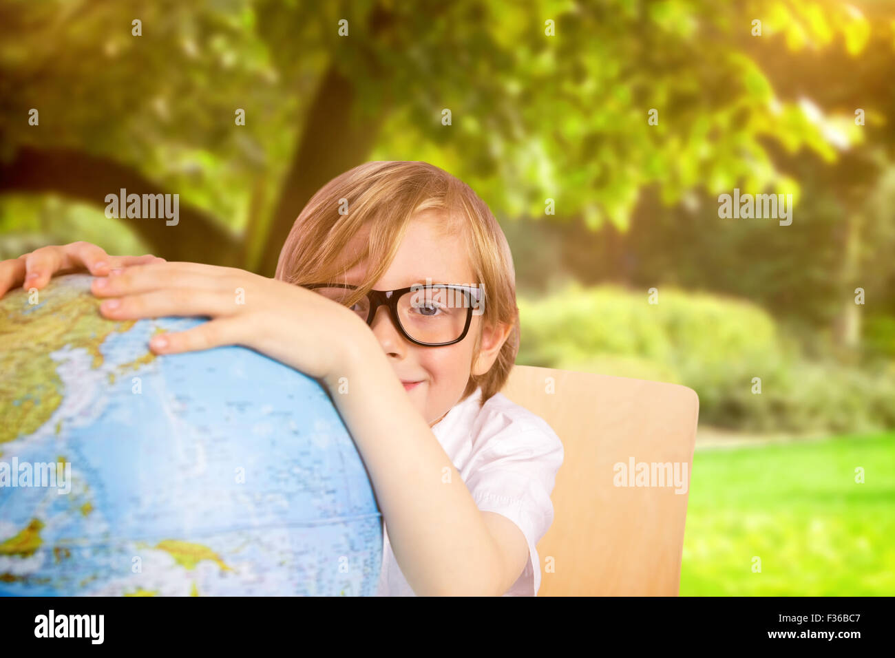 Composite image of cute pupil holding globe Stock Photo - Alamy
