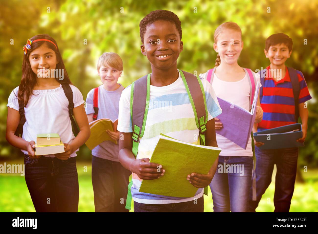 Composite image of smiling little school kids in school corridor Stock Photo