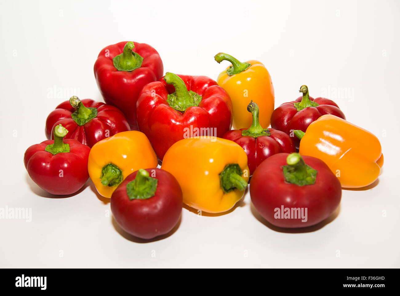 Many red and yellow peppers on a white background Stock Photo - Alamy