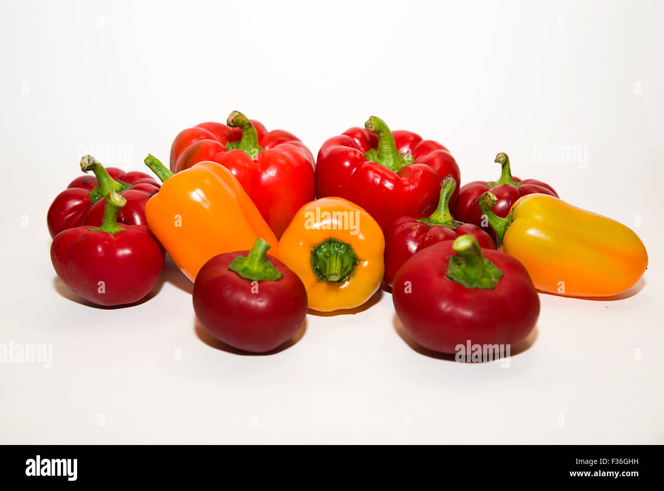 Many red and yellow peppers on a white background Stock Photo - Alamy
