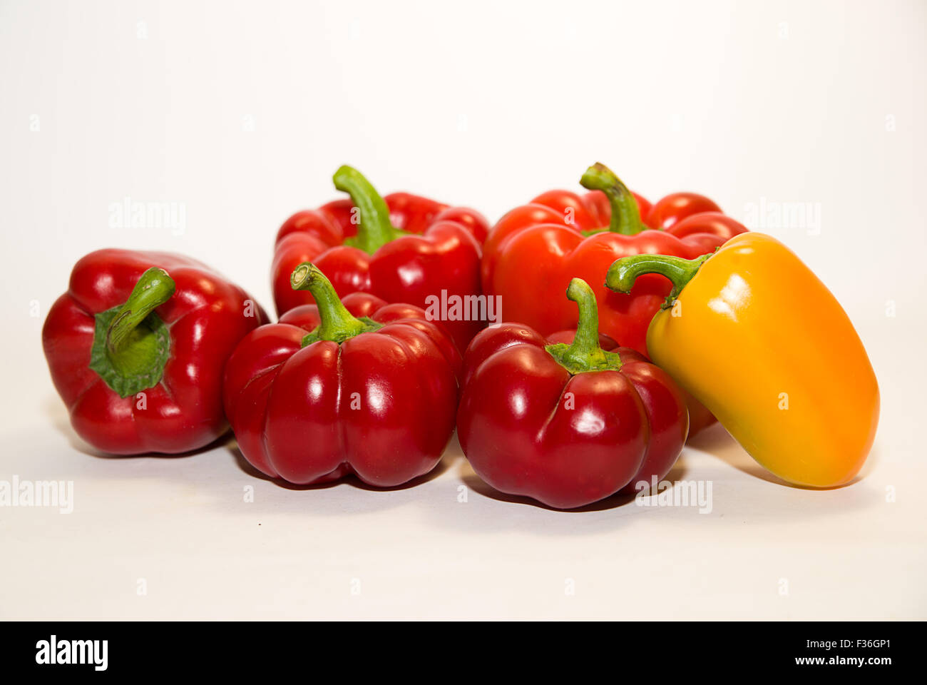 Many red and yellow peppers on a white background Stock Photo - Alamy