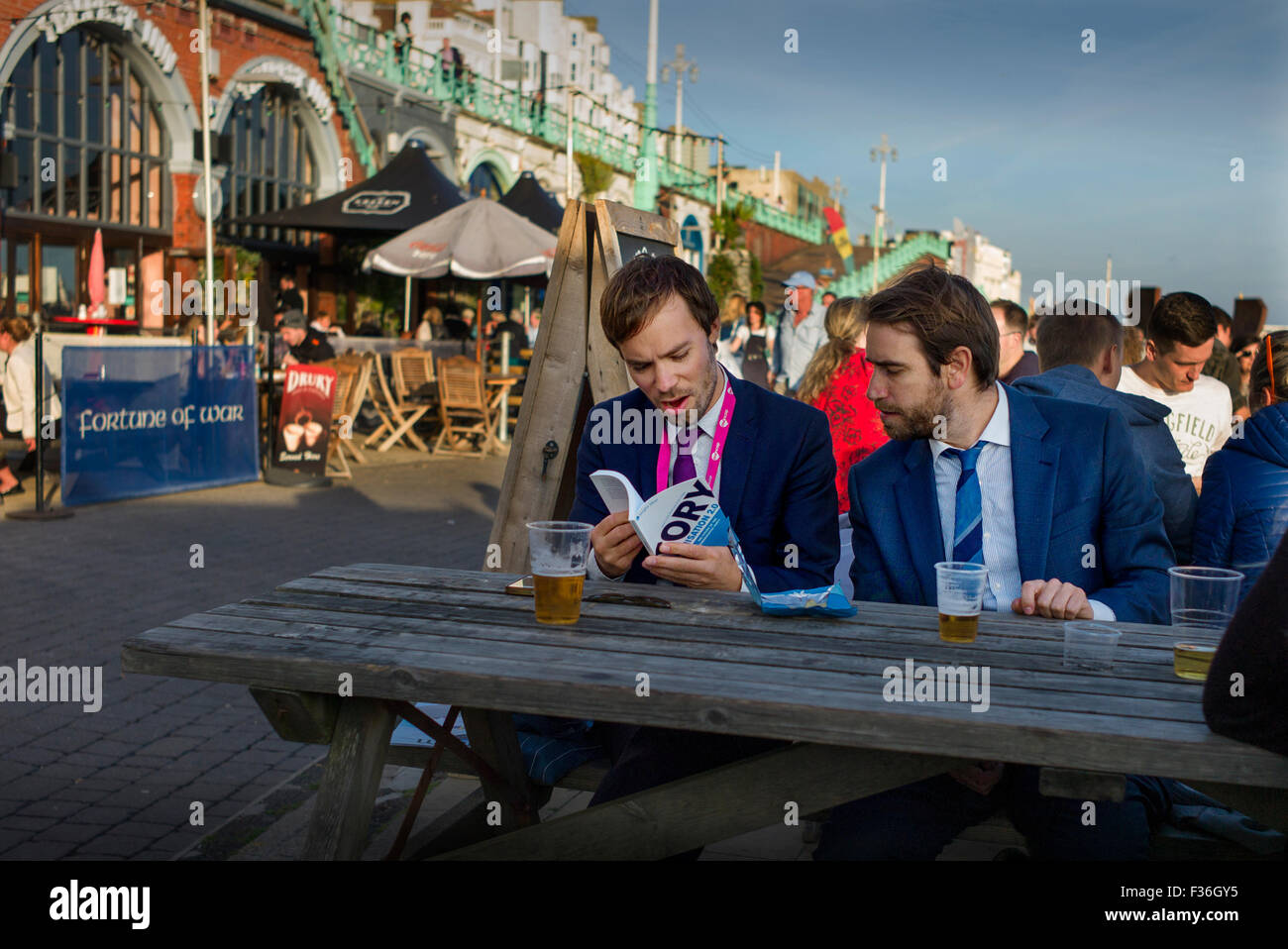 Labour Party Conference attendees refresh themselves on Brighton Sea Front whilst reading a book about the Tory Party. 30 Sept 2015 Stock Photo