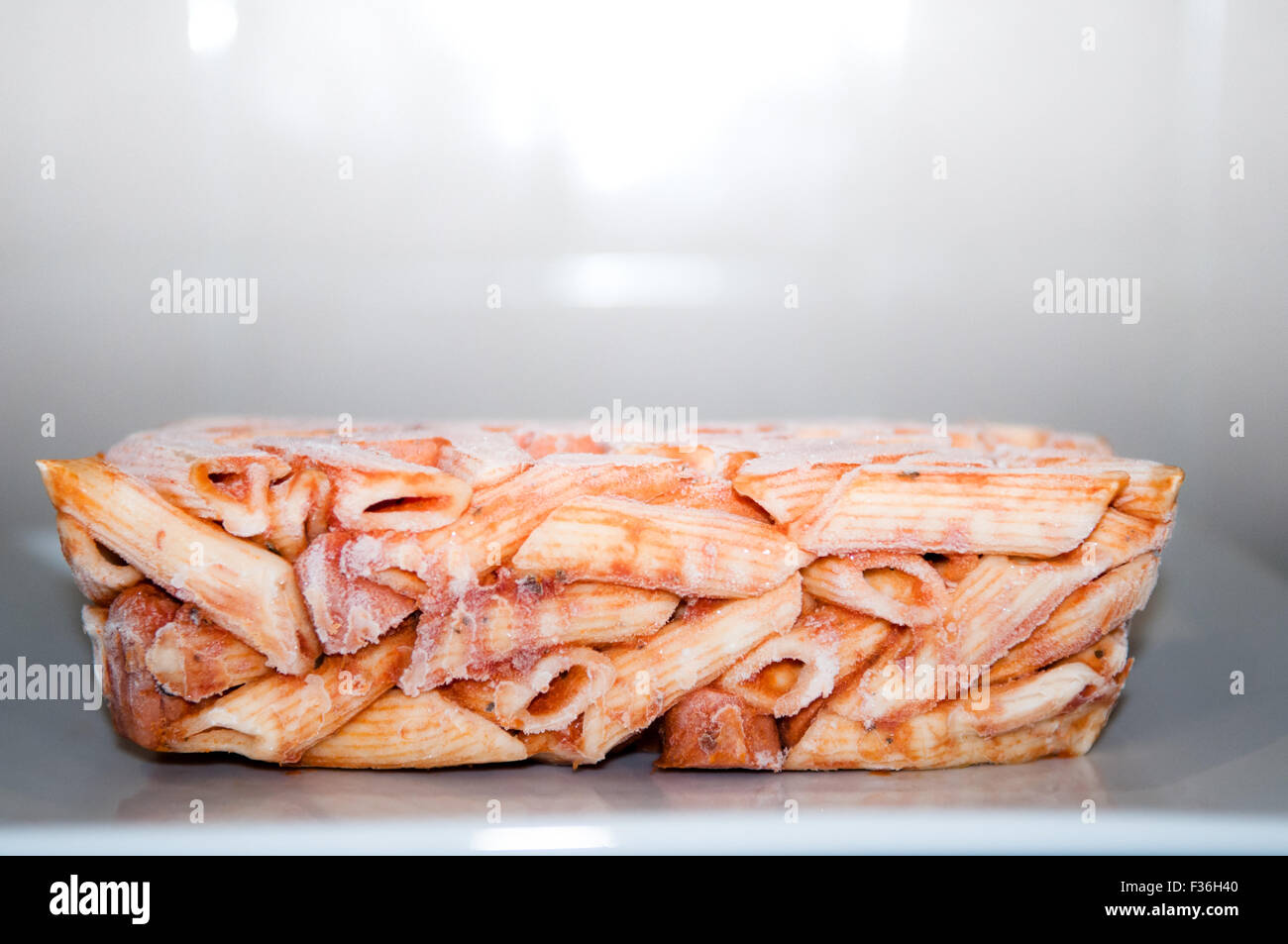 Frozen pasta meal ready for microwave cooking, still in the shape of