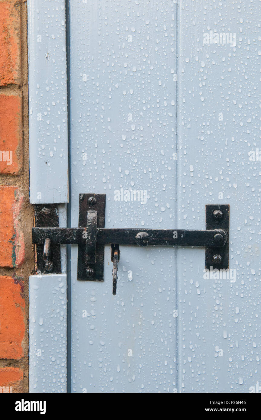 black closed latch securing a blue door Stock Photo