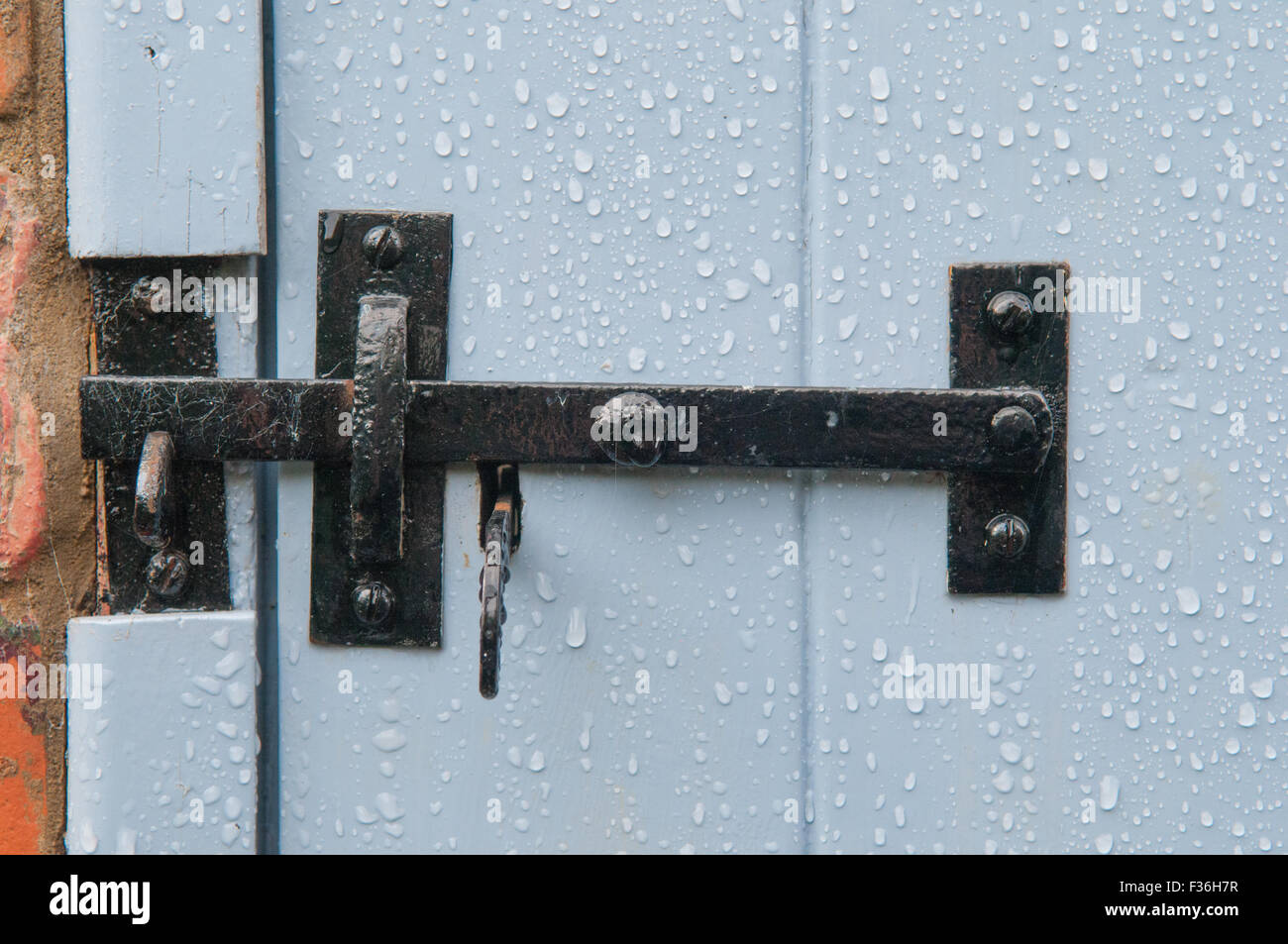 black closed latch securing a blue door Stock Photo