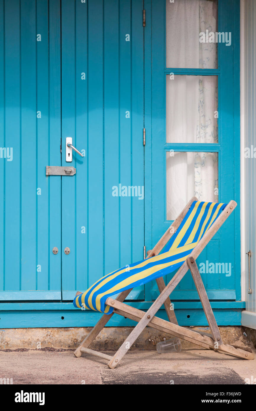 empty deckchair outside beach hut at Bournemouth in September Stock Photo