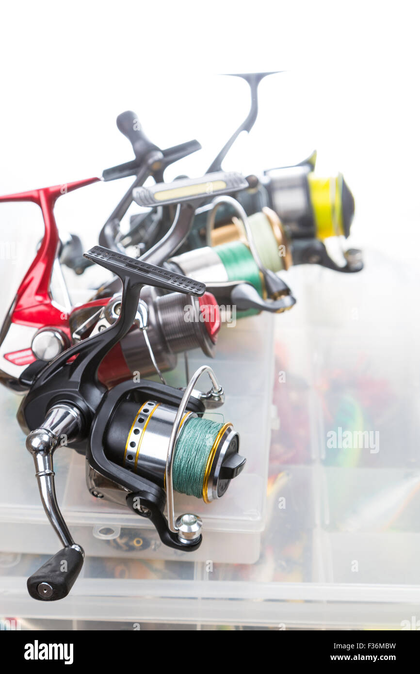 different fishing reels on storage boxes with fishing baits and lures