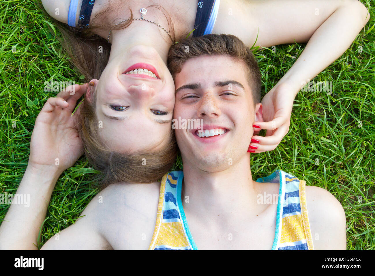 Happy, young couple lying on a meadow Stock Photo