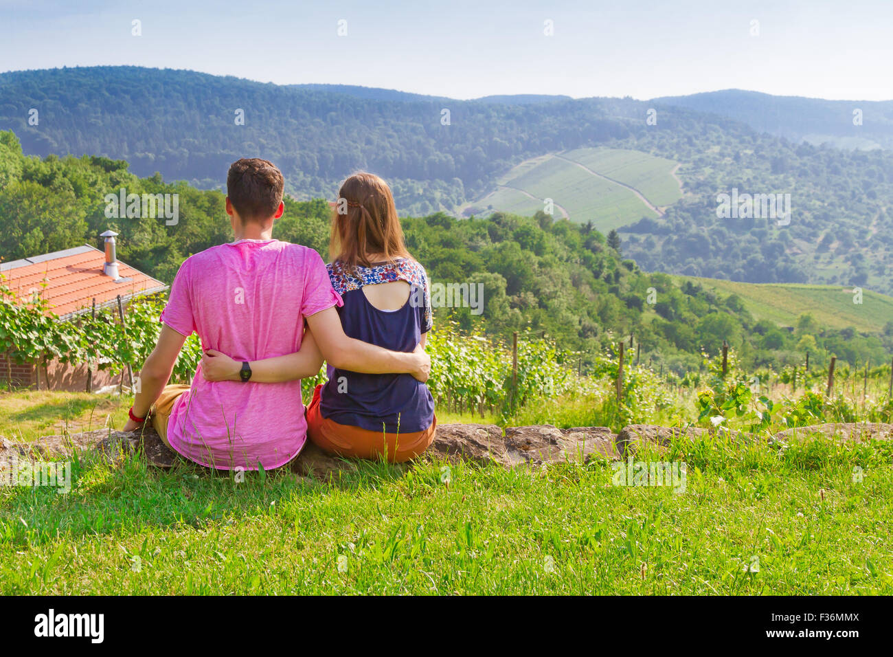 Young love couple sitting on a green meadow Stock Photo
