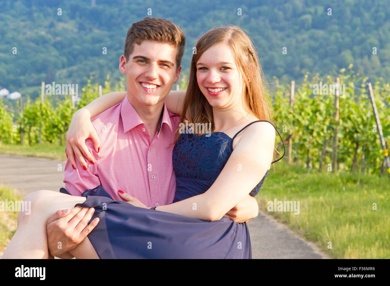 Young, happy man carries his girlfriend Stock Photo