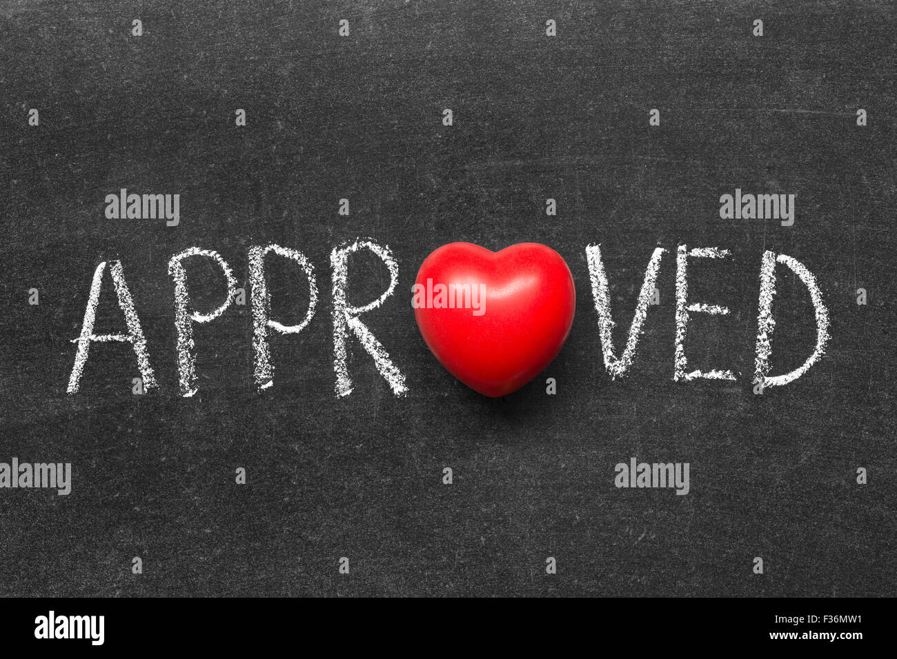 approved word handwritten on blackboard with heart symbol instead of O Stock Photo
