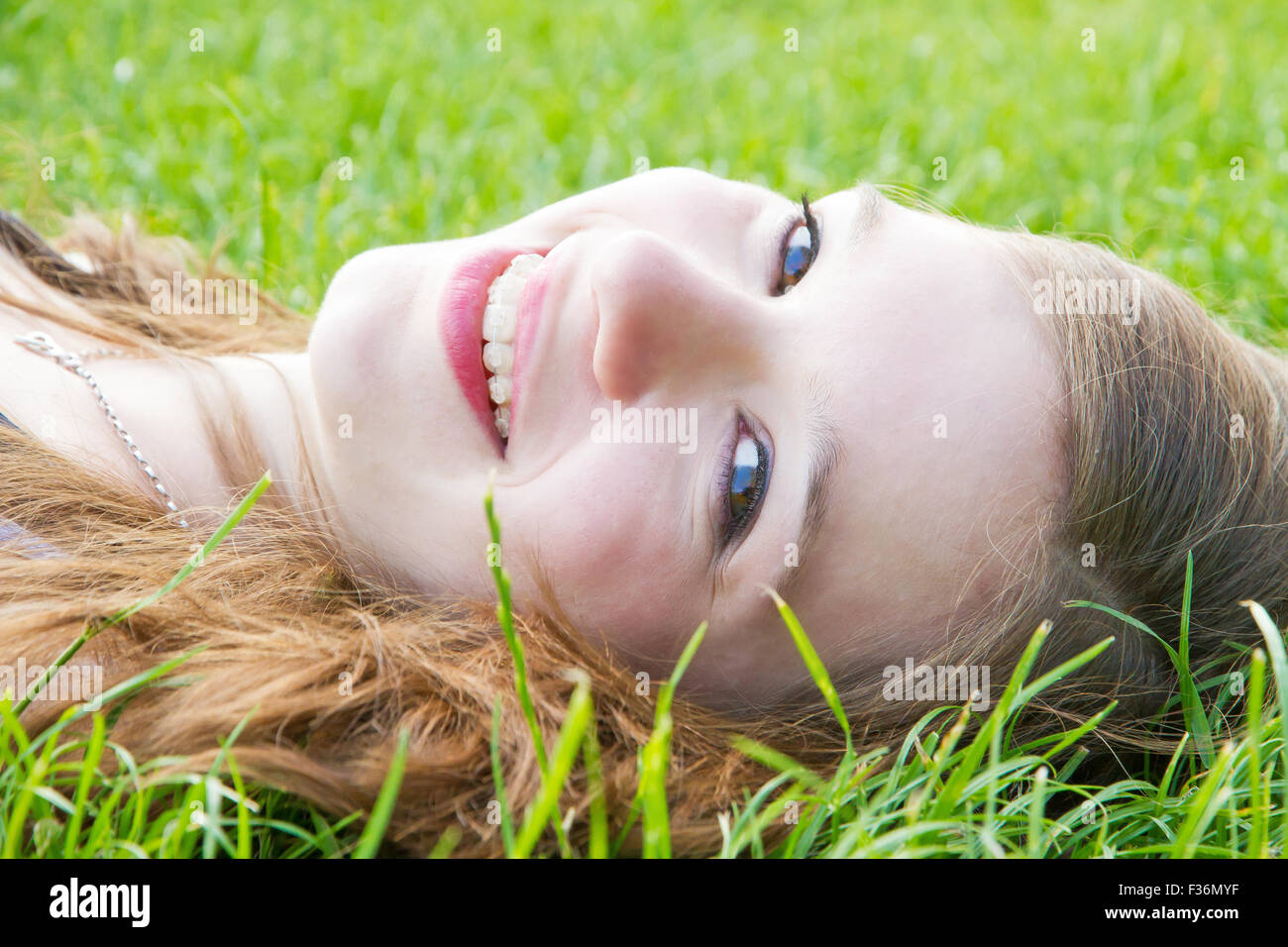 Young happy girl lying in the grass Stock Photo
