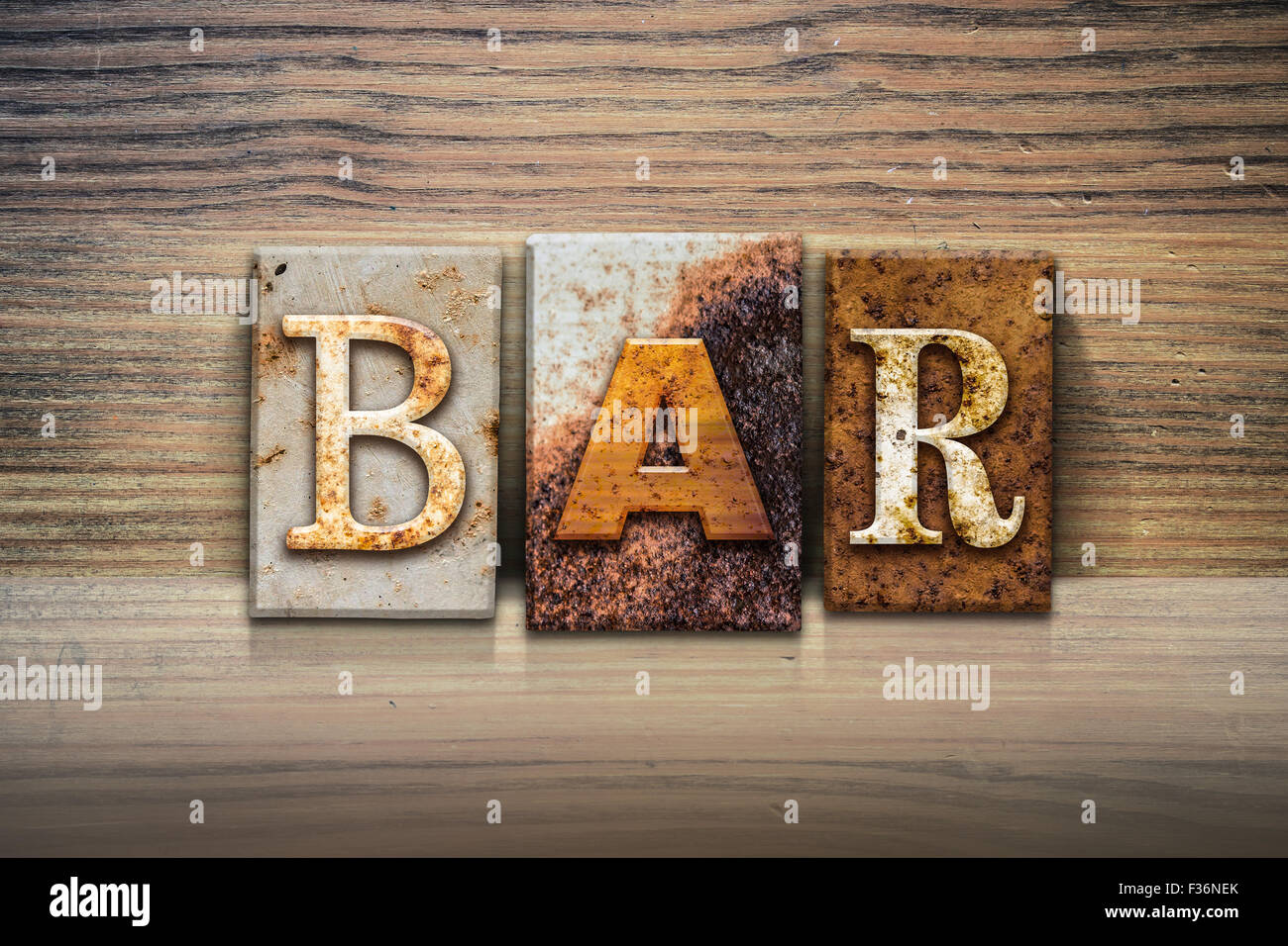 The word "BAR" written in rusty metal letterpress type sitting on a