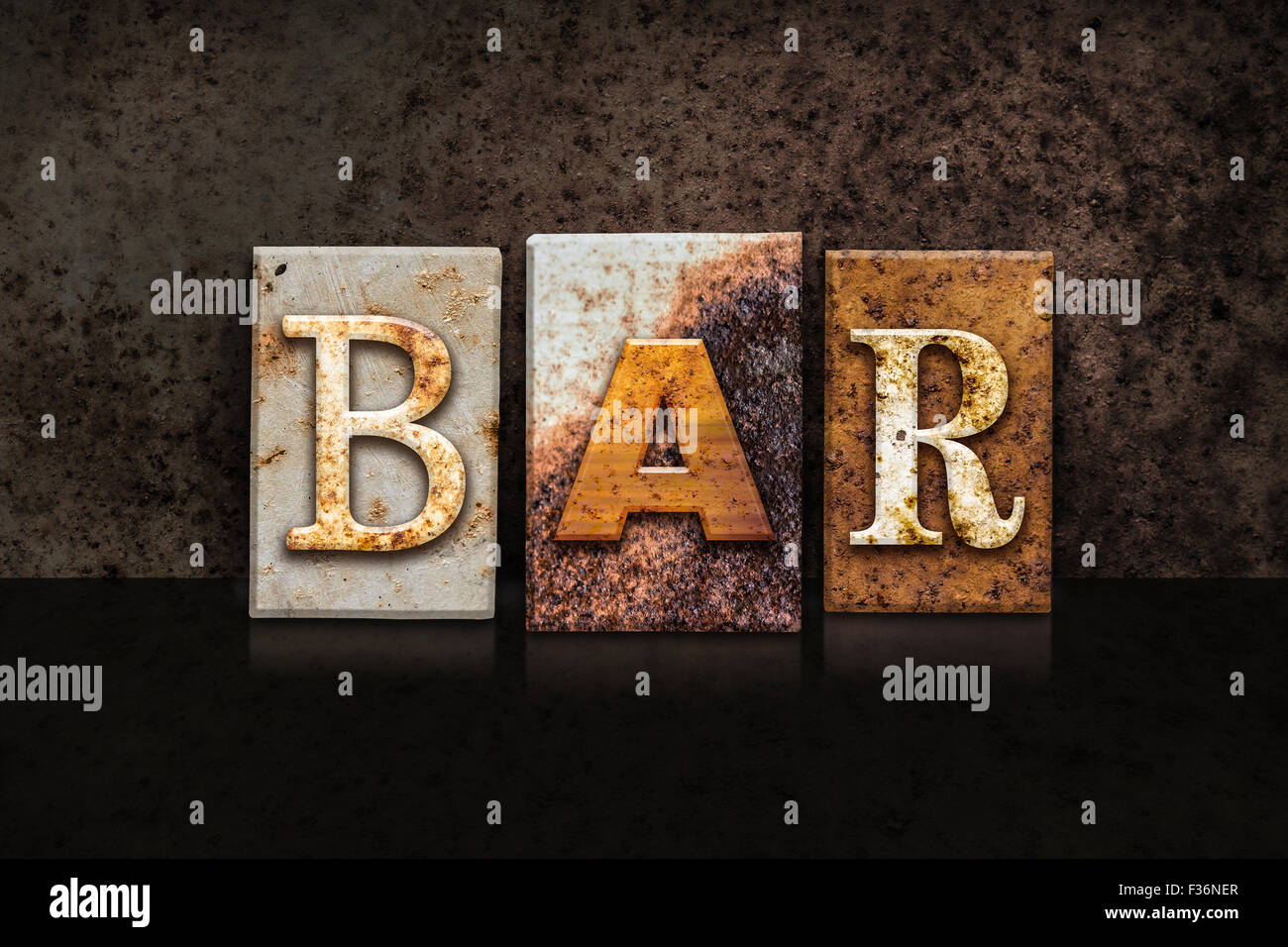 The word "BAR" written in rusty metal letterpress type on a dark