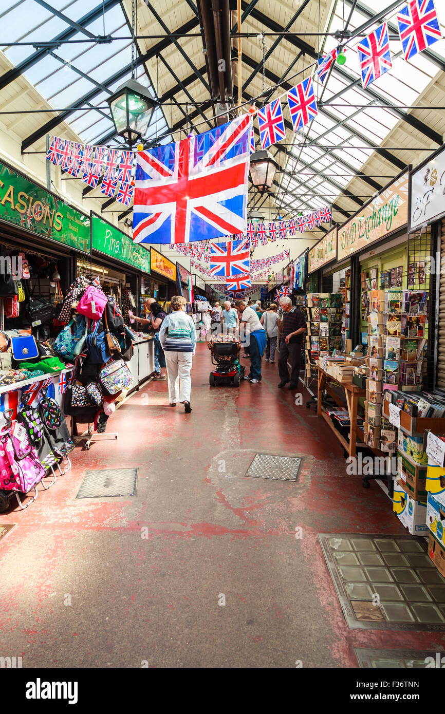 Shoppers at Leek indoor trestle market a typical traditional British indoor market with union jack flags and Victorian lights Stock Photo