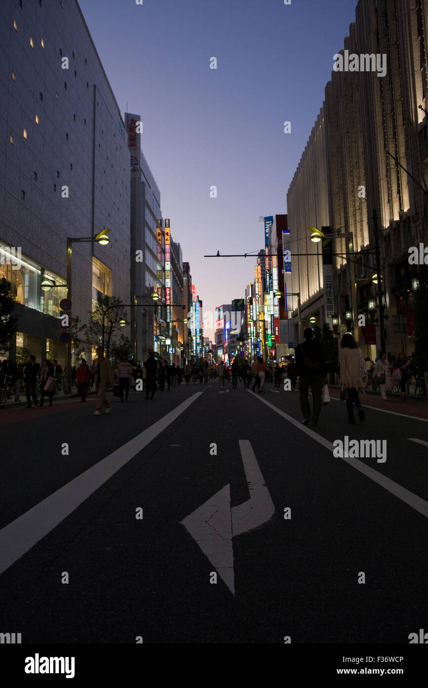 Middle of the street with a row of buildings at night with giant turn right arrow foreground Stock Photo