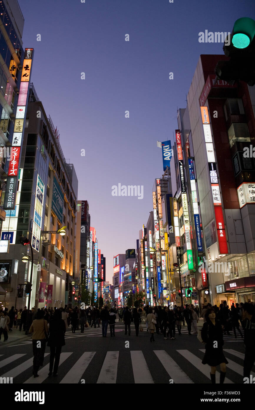 Middle of the street with a row of buildings at night with bright colorful signs Stock Photo