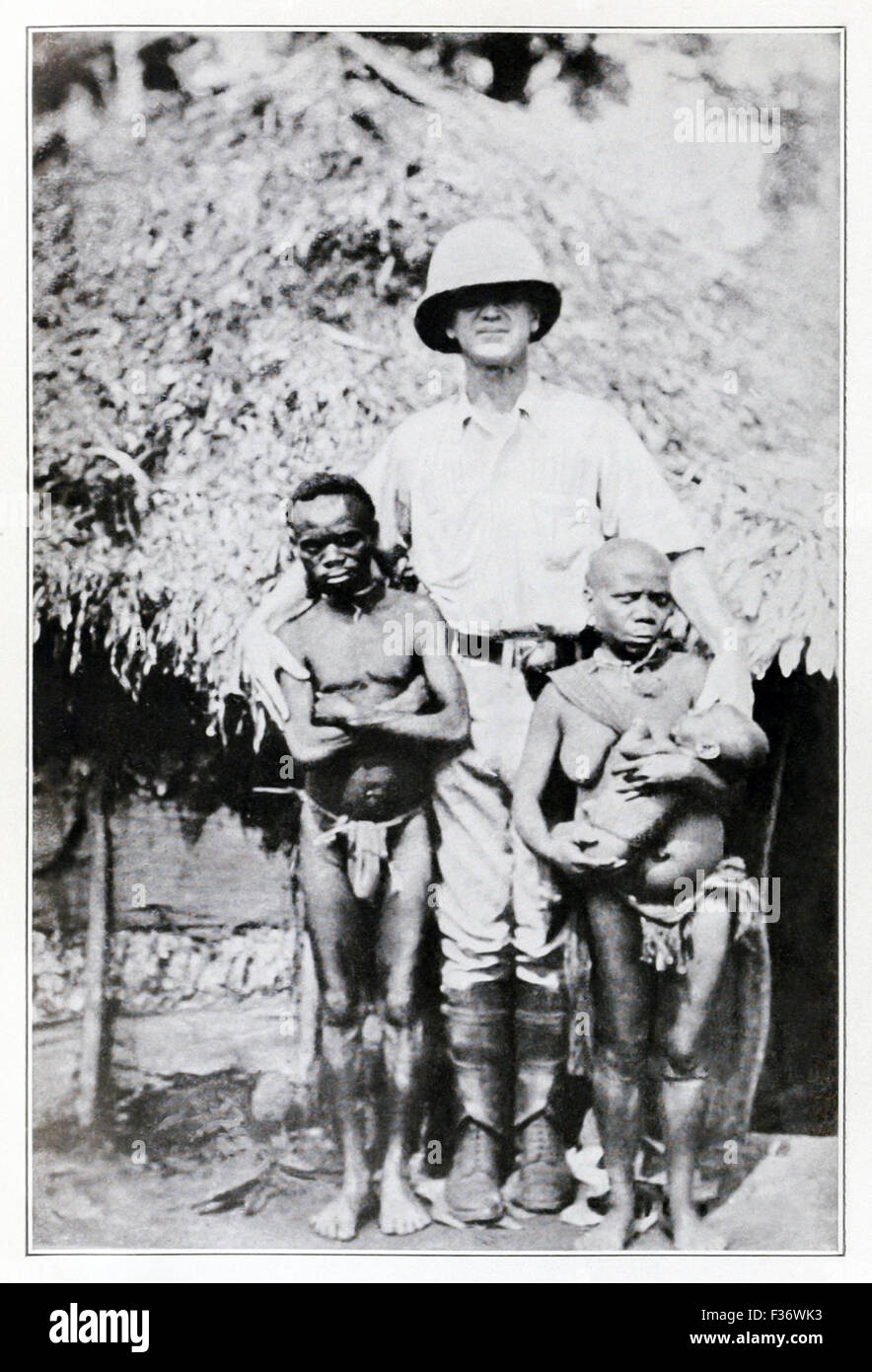 'African Pigmies discovered by explorers.' Congo Pygmies outside their home in Central Africa, photographed before 1921. Stock Photo