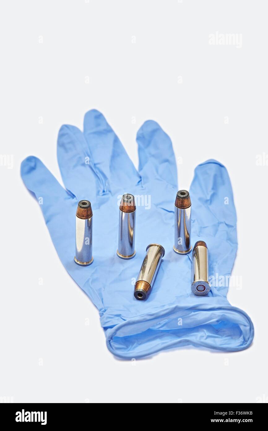 357 Magnum Pistol Cartridges 125GR JHP in Blue Latex Forensic Glove Stock Photo