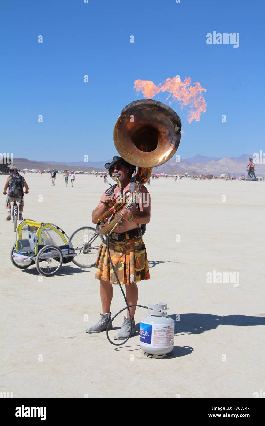 A burner plays a flaming tuba during the annual Burning Man festival in the desert August 27, 2014 in Black Rock City, Nevada. Stock Photo