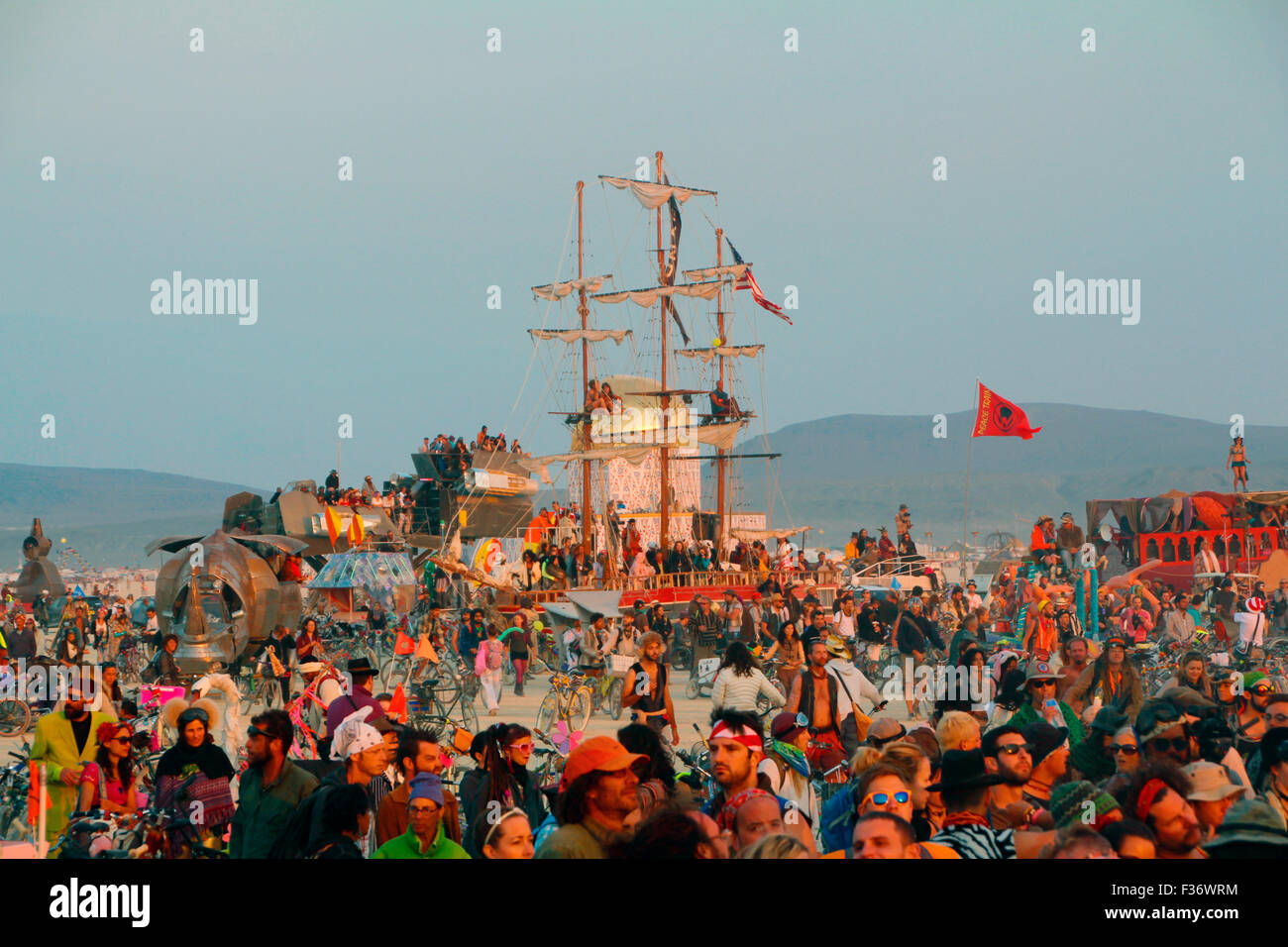 Burners gather for the sunset in the playa during the annual Burning Man festival in the desert August 26, 2014 in Black Rock City, Nevada. Stock Photo