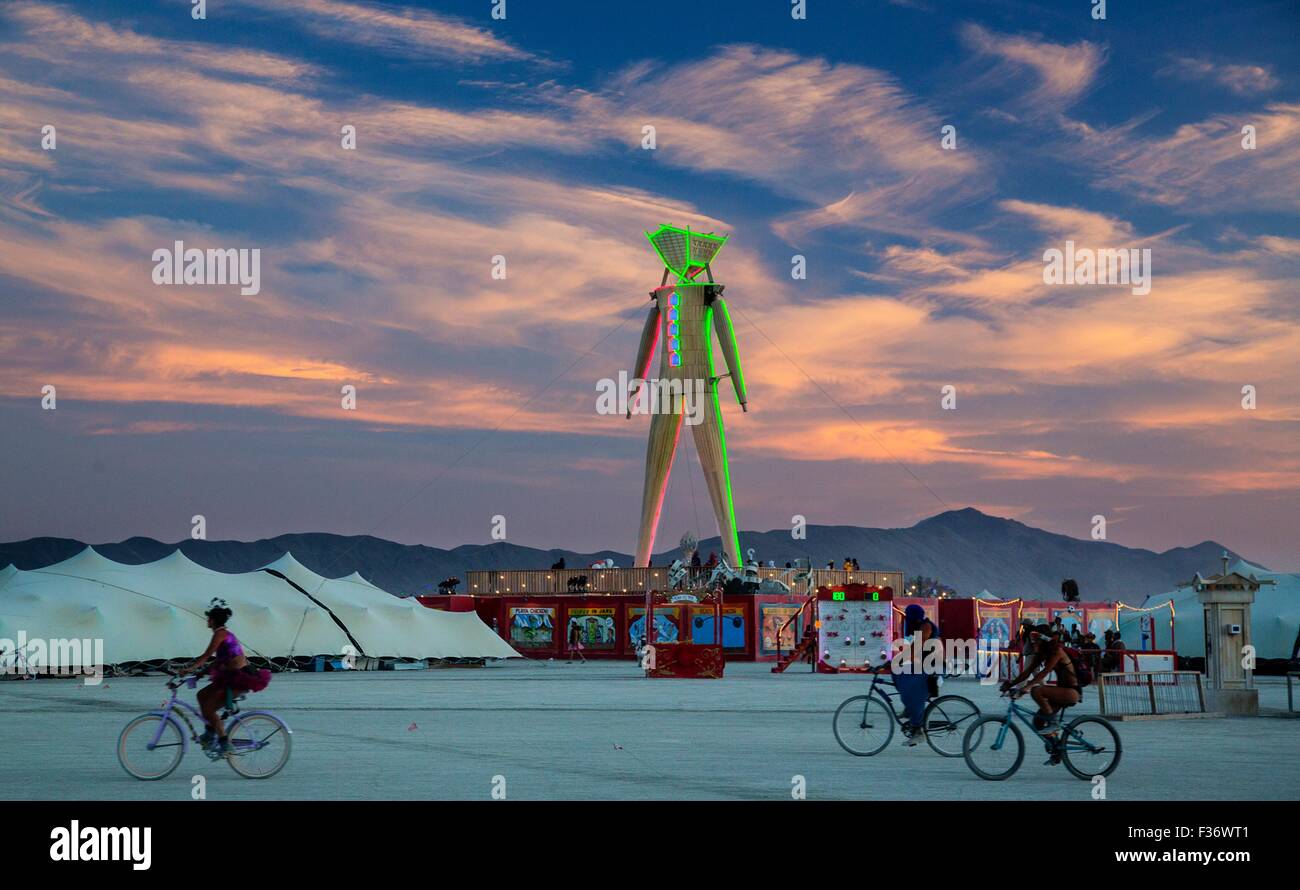 Burner bikes cruise the playa at sunset during the annual Burning Man festival in the desert August 30, 2012 in Black Rock City, Nevada. Stock Photo