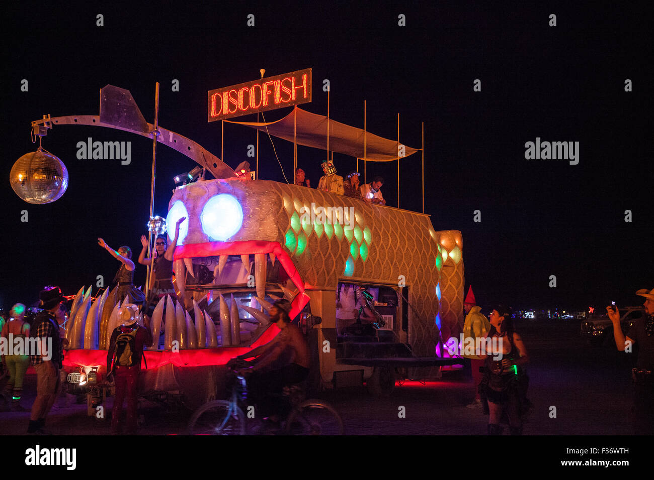 The disco fish art car cruises at night in the playa during the annual