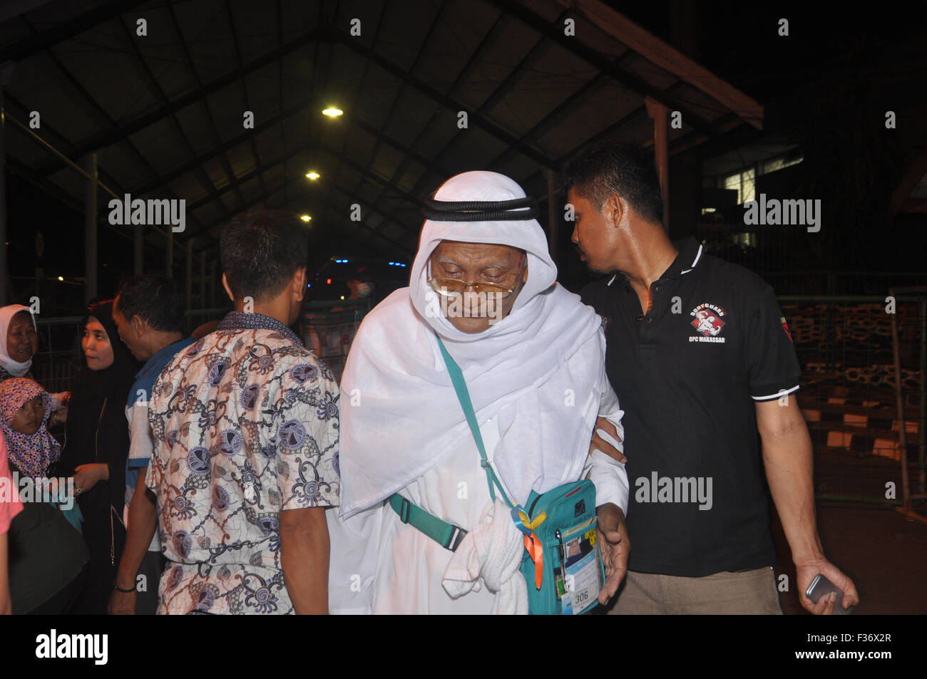 Makassar, Indonesia. 30th Sep, 2015. Indonesian hajj pilgrim assisted by his family at Sudiang Hajj Hostel Complex in Makassar, Indonesia following his return from Saudi Arabia on September 30, 2015.  Indonesia departed 168.800 hajj pilgrim to Saudi Arabia this year, but it is expected hudred of the pilgrim dead during rencent hajj season. Indonesian Religious Afair has not confirm exact number of hajj dead due to collecting correct data following the Mina Tragedy that killed around 1000 pilgrim. Credit:  Yermia Riezky Santiago/Alamy Live News Stock Photo