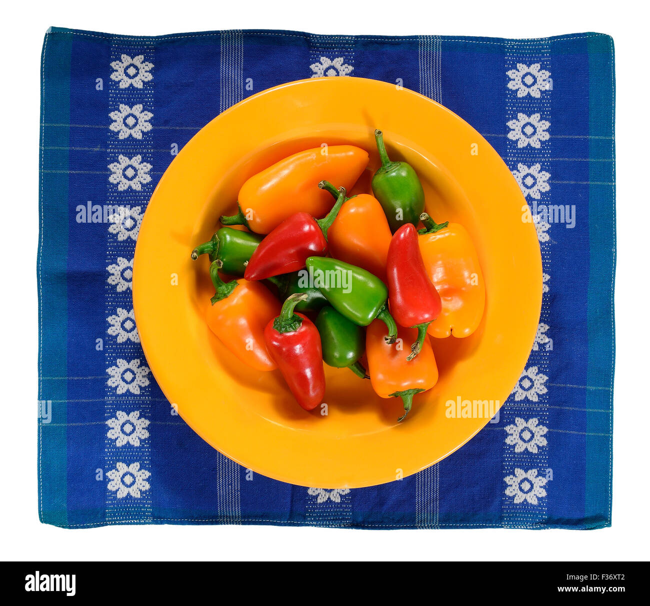 Green, yellow and red hot chilly peppers in plate, isolated on white. Stock Photo