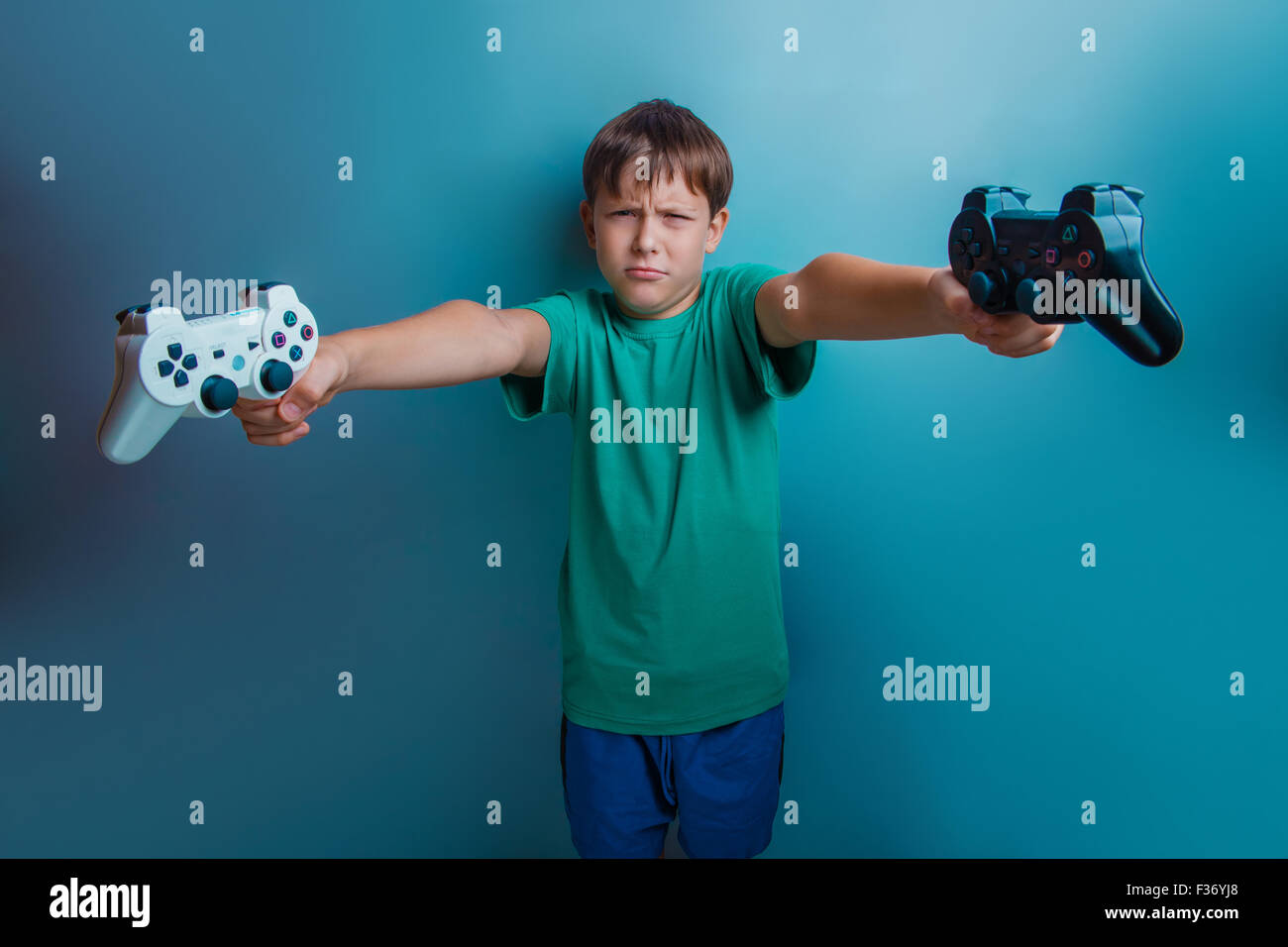 Teen  boy of twelve European  appearance holds a  gaming zhdoyst Stock Photo