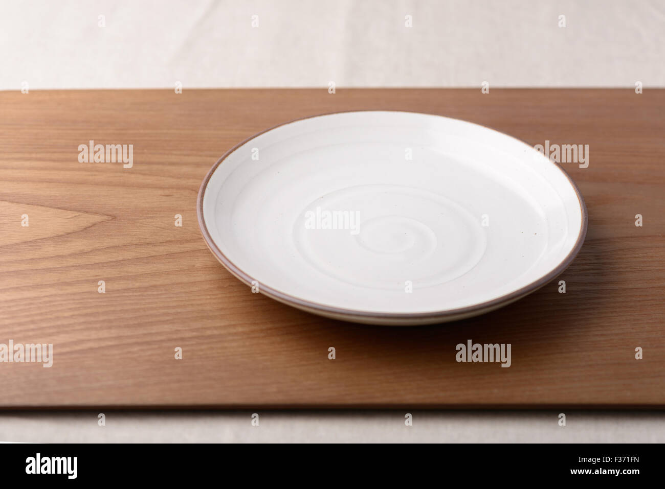 Empty ceramic dish on a wooden plate Stock Photo