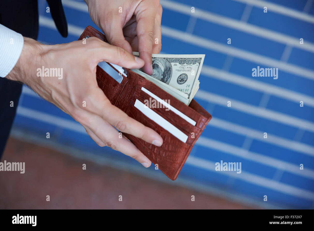man holding a purse with money closeup Stock Photo - Alamy