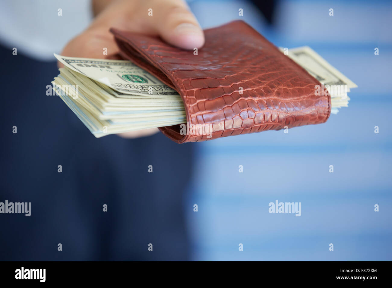 man holding a purse with money closeup Stock Photo - Alamy