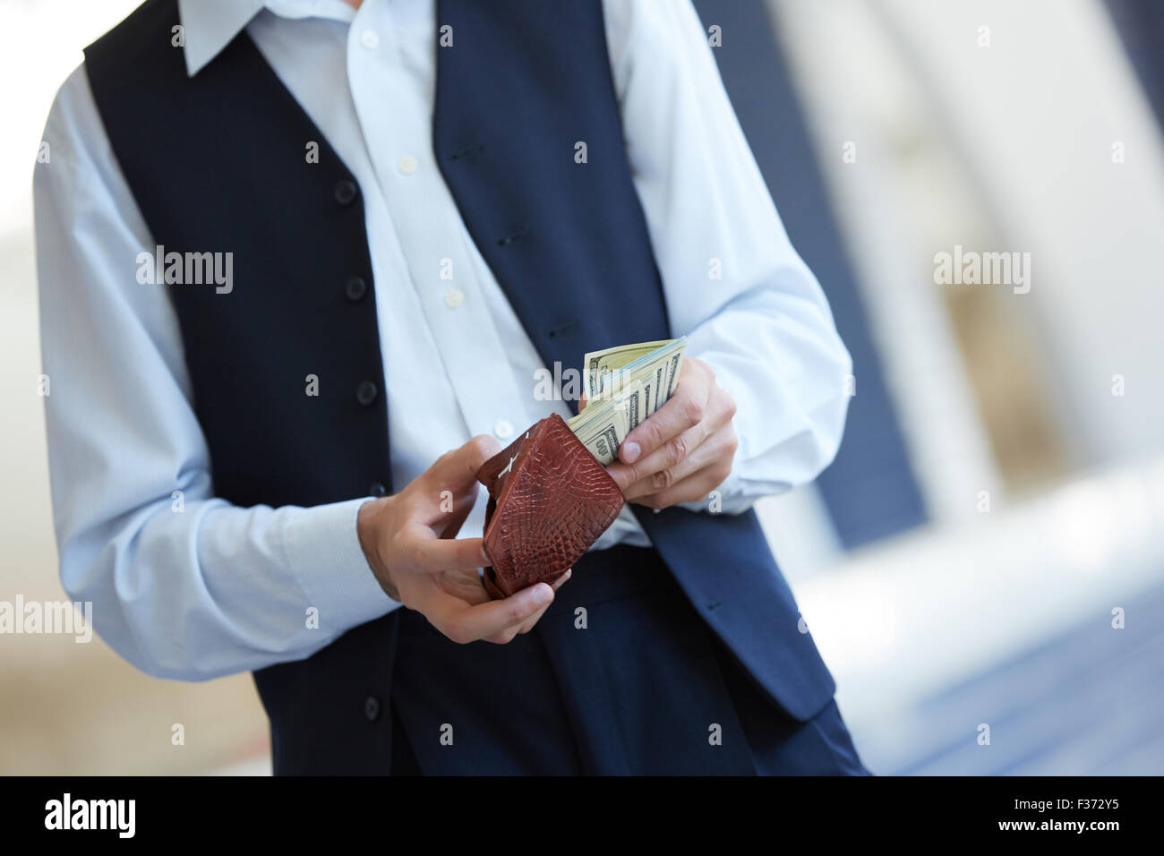 man holding a purse with money Stock Photo - Alamy