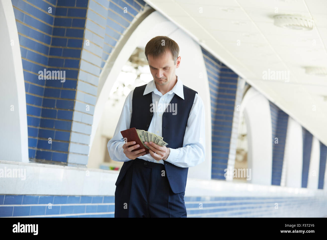 man holding a purse with money Stock Photo - Alamy