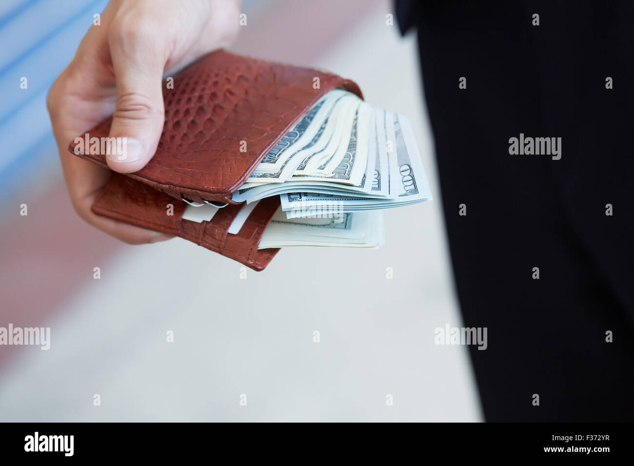 man holding a purse with money closeup Stock Photo - Alamy