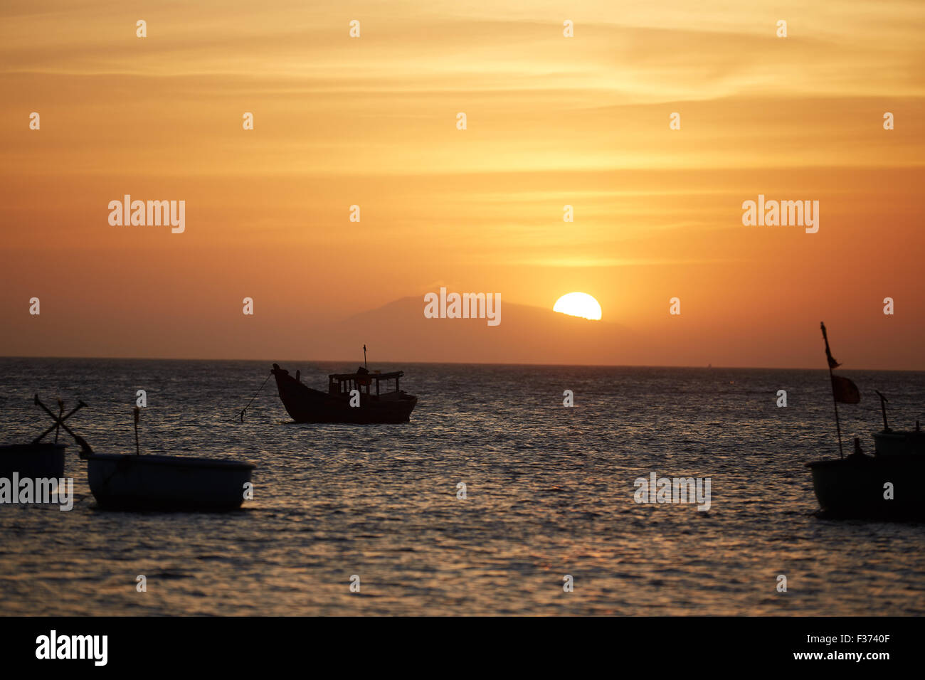 Fishing boats at sunset Stock Photo - Alamy