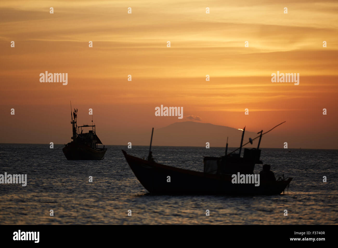 Fishing boats at sunset Stock Photo - Alamy