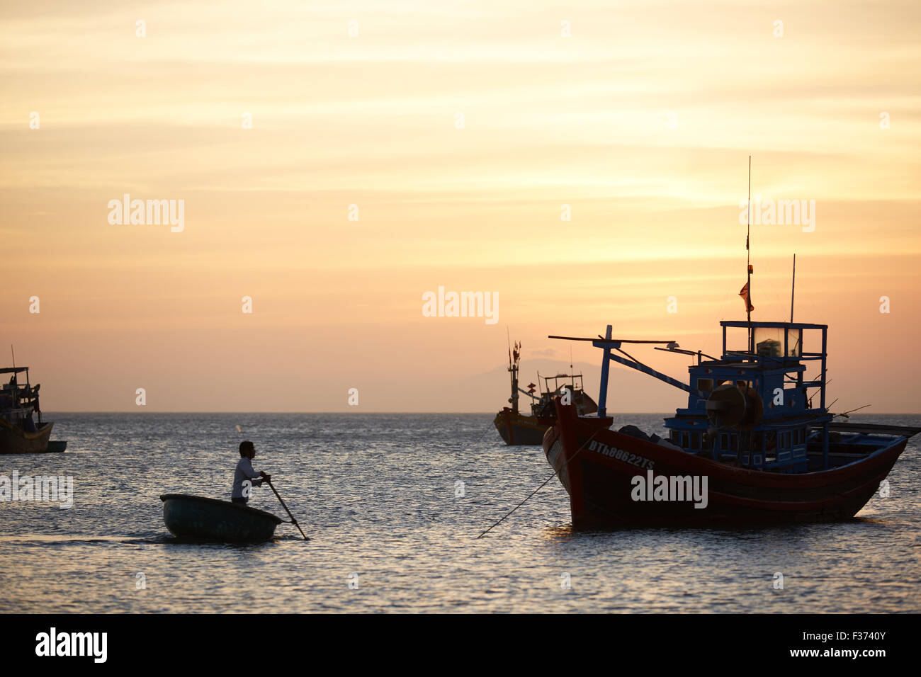 Fishing boats at sunset Stock Photo - Alamy