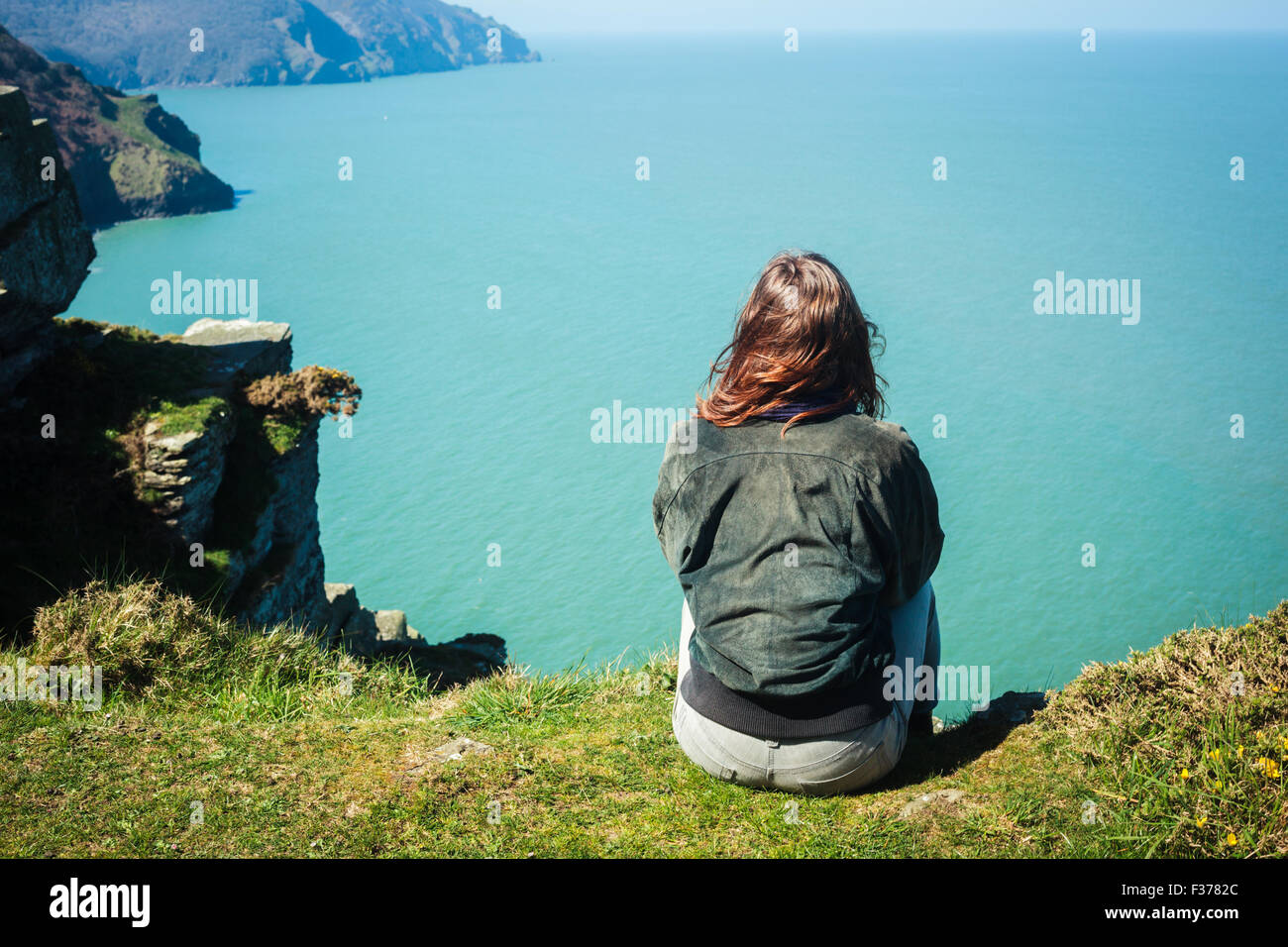 Girl sitting on edge cliff hi-res stock photography and images - Alamy