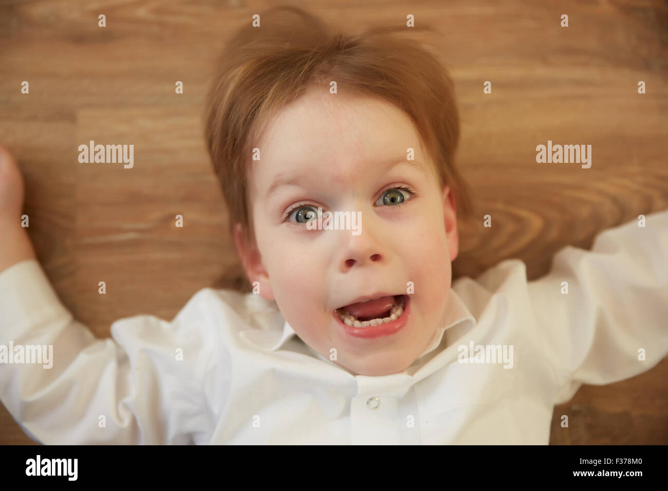 emotional cheerful boy lying on the floor Stock Photo - Alamy