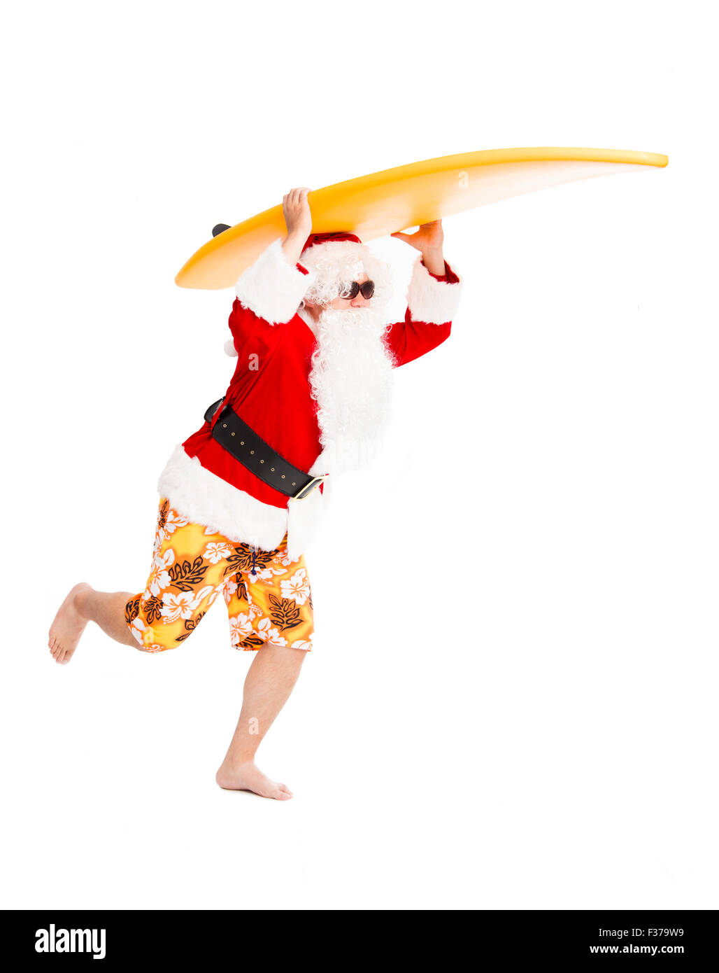 Happy Santa Claus running with surf board Stock Photo