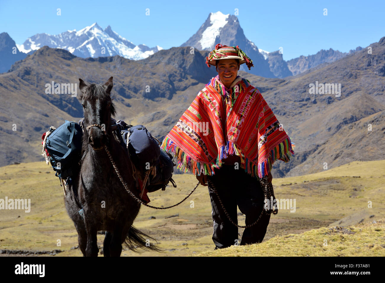 Indio mountain guide with colorful poncho and horse, in the mountains,  Andes, Cusco Province, Peru Stock Photo - Alamy