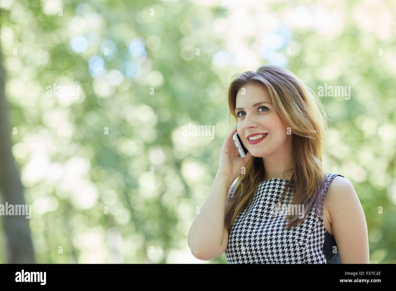 beautiful girl in a park is holding a phone Stock Photo - Alamy