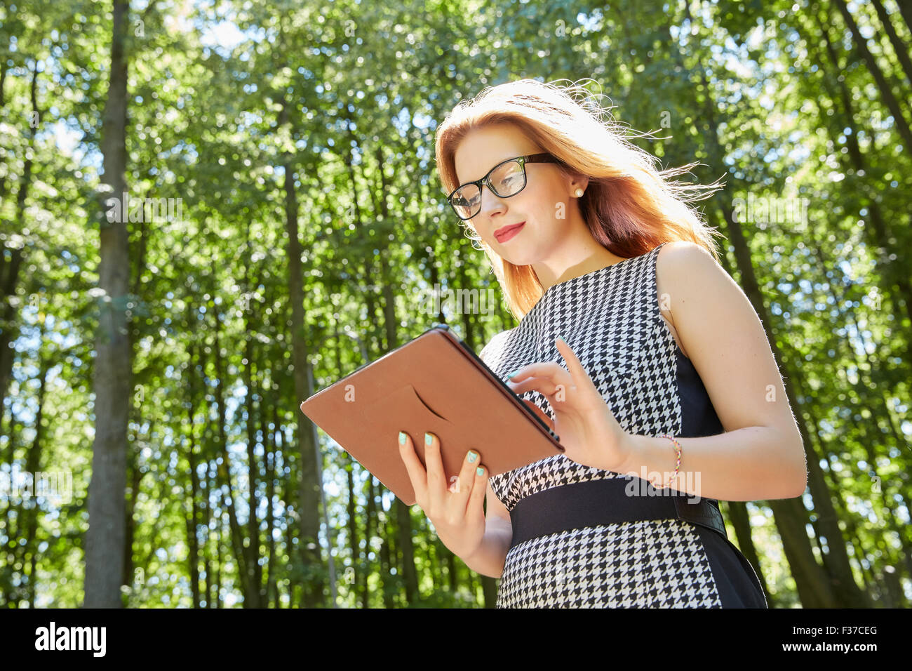 beautiful girl in the park holding a tablet Stock Photo - Alamy