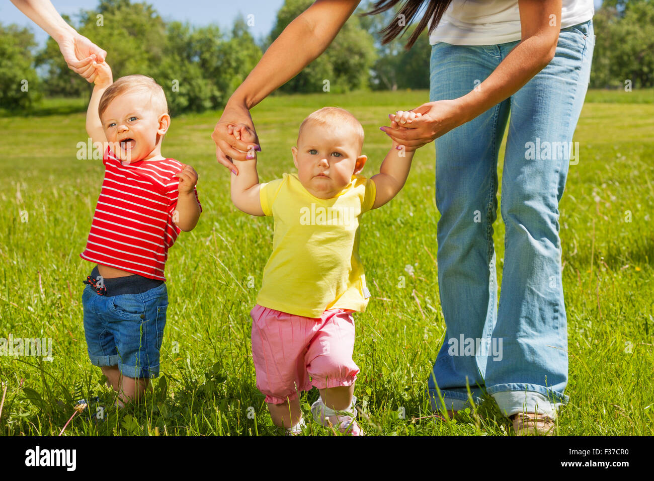 Babies learn how to walk holding mothers hands Stock Photo Alamy