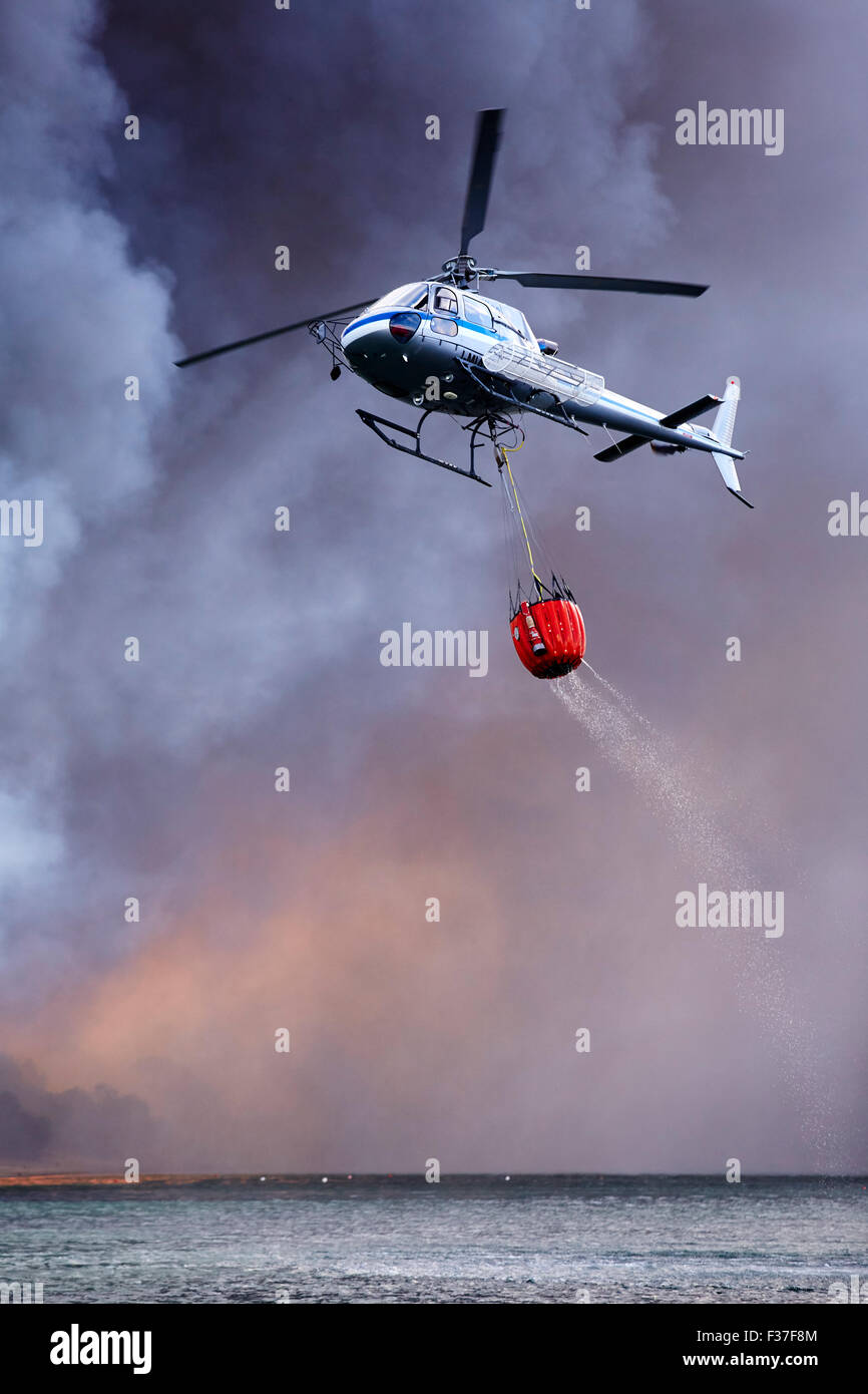Firefighting Helicopter dousing forest fire over Sardinia Stock Photo